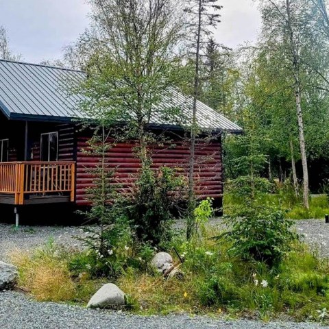 a small house surrounded by grass