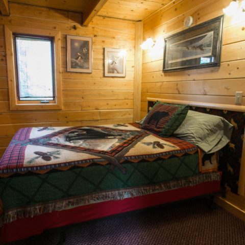 a bedroom with a bed and desk in a small room