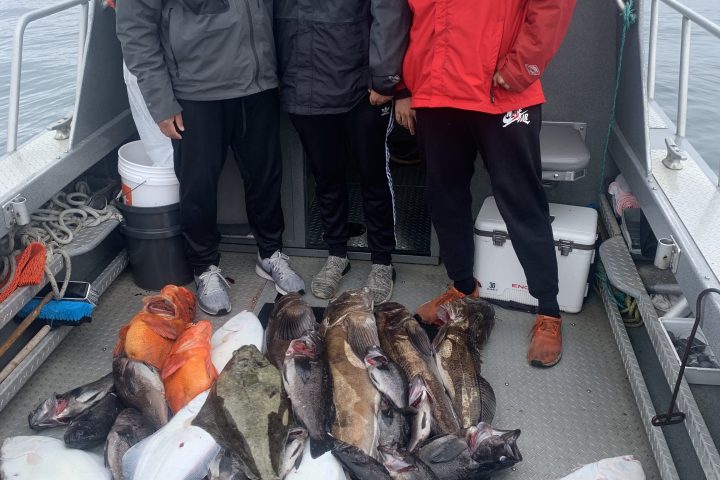 a group of people posing for a fish