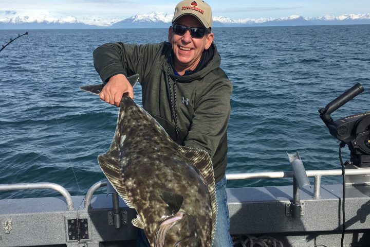 a man sitting on a bench next to a body of water